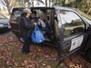 Volunteer driver Joanne Pritchard, left, hands a shopping bag to Crown Villa Apartments resident Linda Crooks as they prepare for a trip to Walmart on Friday afternoon. The ride was free through the Human Services Council&#039;s new Volunteers in Motion program.