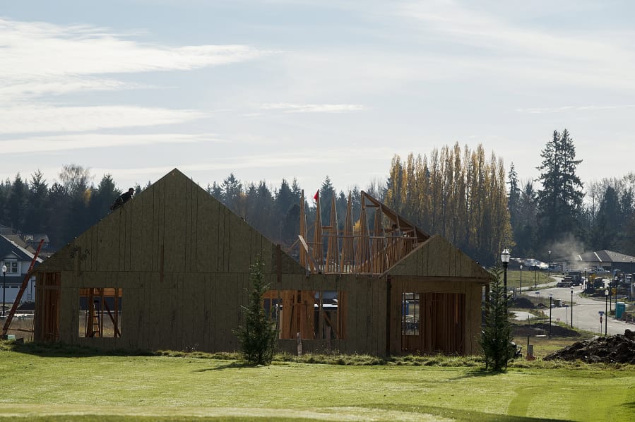 Construction workers work on a home in Cedars Village, a new subdivision in southeast Battle Ground.