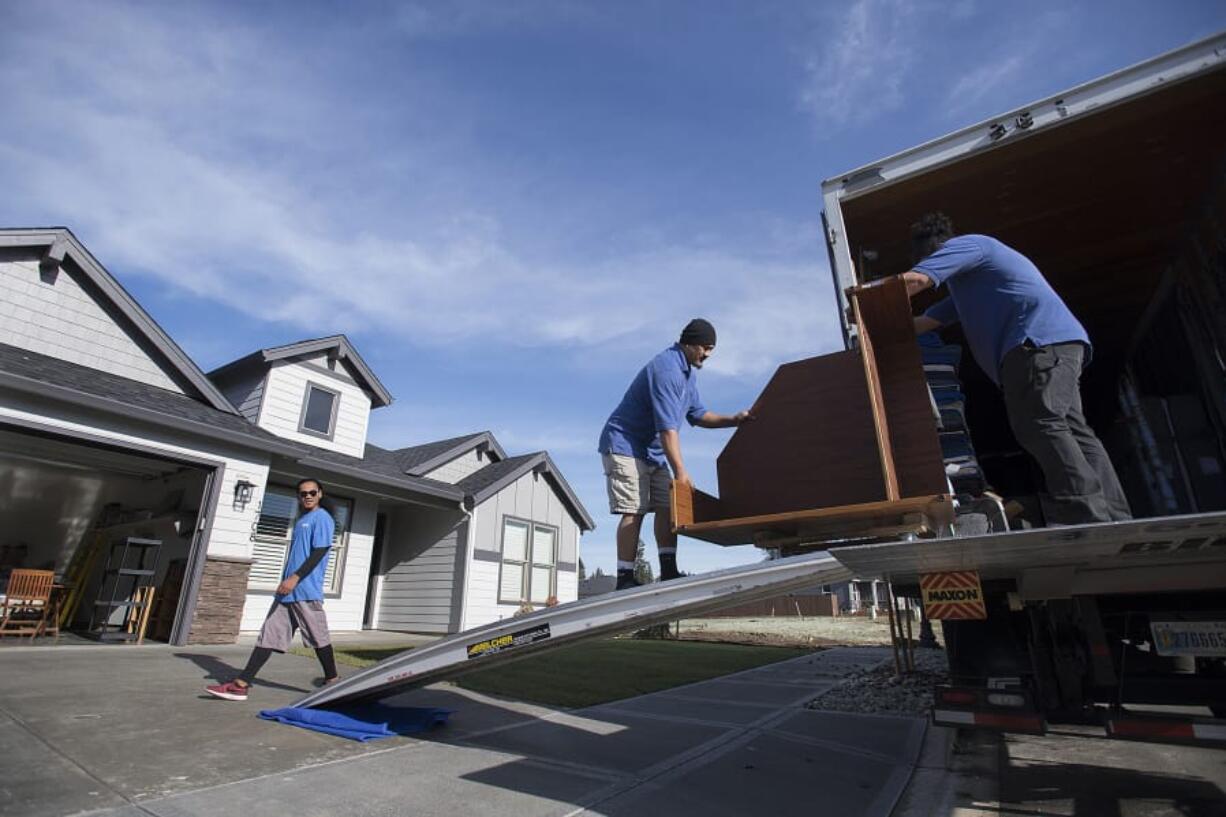 Ivan Heather, from left, of Big Al&#039;s Specialty Movers joins colleagues Leonard Malauulu and George Aiono as they transport furniture into a new home in southeast Battle Ground&#039;s Cedars Village on Monday morning.