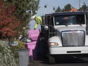 Ben Dynes, a driver with Waste Connections, drops off a pink recycle bin in honor of breast cancer awareness at a home along Devine Road on Wednesday morning, Nov. 6, 2019.