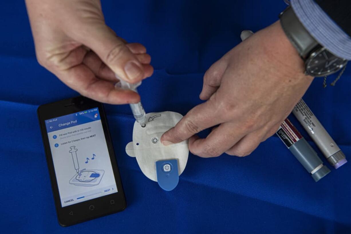 Tera Malmquist with Omnipod Insulin Management System demonstrates her company&#039;s automated insulin injector during a World Diabetes Day event at Legacy Salmon Creek Medical Center. Technology has made living with diabetes more manageable than it once was.