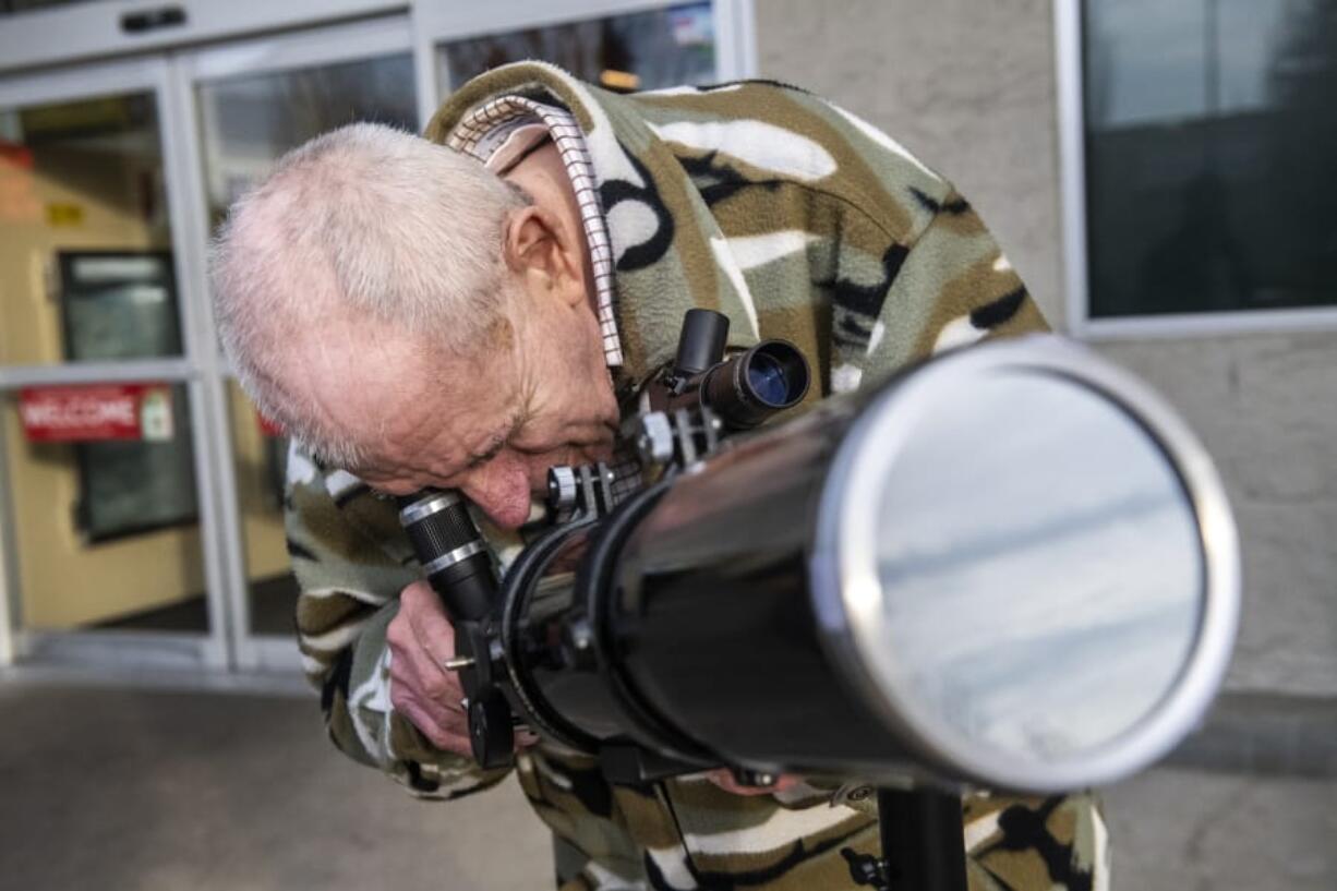 Stan Seeberg with the Vancouver Sidewalk Astronomers Club watches the transit of Mercury in front of the sun while in the parking lot of the Hazel Dell Safeway on Monday morning.