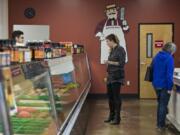 Josh Juarez of Butcher Boys, left, prepares an order for customer Lady Bond of Woodland, center, while working behind the counter on Tuesday afternoon.