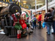 Santa&#039;s elves Holly and Jolly pose for a photo with Adelyn Bodossian, 5, outside &quot;The Polar Express&quot; set in Vancouver Mall.