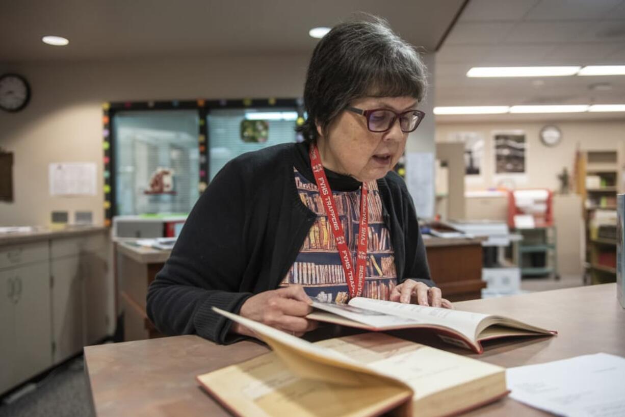 High school librarian Kate Burton flips through the 1943 Alki yearbook at Fort Vancouver High School, looking for a photo of Francis Elaine Bailey.