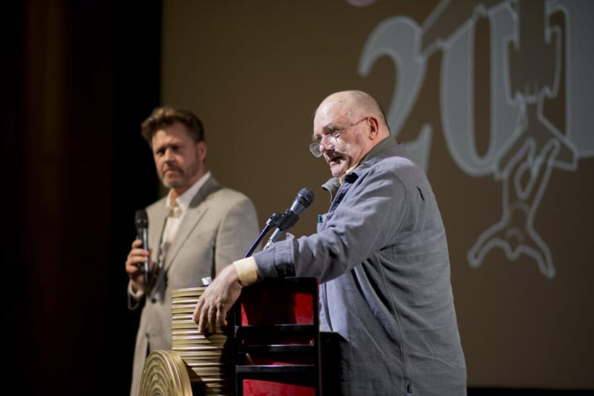 CooperCon founder Eric Ulis, left, and author Bruce Smith moderate a Cooper-themed trivia contest Saturday afternoon at the Kiggins Theatre in downtown Vancouver. The event moved from Portland to Vancouver this year and featured talks on specifics from the case, a film about Cooper and plenty of theories on what happened nearly 50 years ago. At top: Rick E. George, author of the book &quot;Cooper&#039;s Loot,&quot; listens as a forensics film plays during Saturday&#039;s CooperCon festivities.