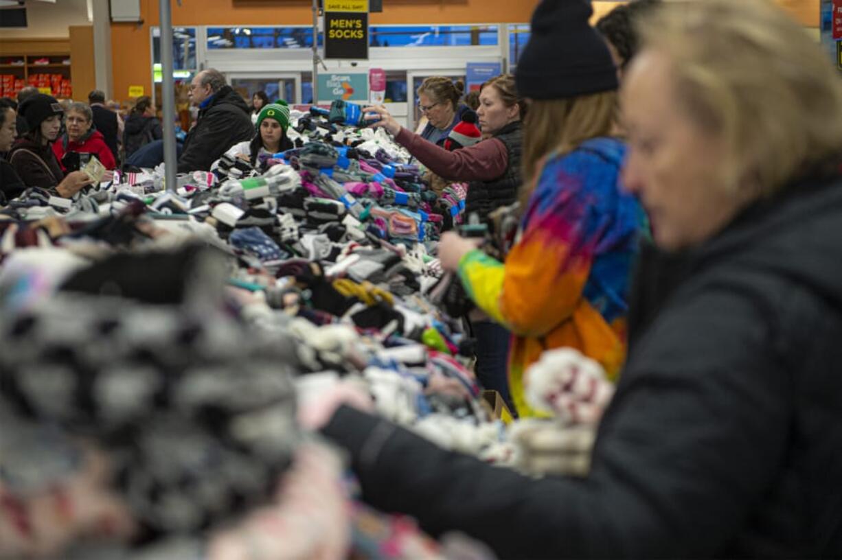 Shoppers search through piles of socks during the Black Friday sock sale at Fred Meyer on Friday morning. The department store chain expects to sell more than a million pairs of socks in total on Black Friday.