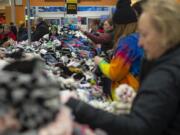 Shoppers search through piles of socks during the Black Friday sock sale at Fred Meyer on Friday morning. The department store chain expects to sell more than a million pairs of socks in total on Black Friday.