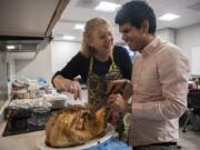 Vancouver Mayor Anne McEnerny-Ogle helps Caples Terrace resident Miguel Viveros carve the turkey for a community Thanksgiving meal. Viveros is blind and had never carved a turkey before. &quot;It&#039;s so much fun,&quot; he said. &quot;It smells super good.&quot; McEnerny-Ogle and Jodi Freydenfeldt, self-sufficiency coordinator and case manager for Caples Terrace, a new Vancouver Housing Authority building, organized the Thanksgiving cooking demonstration and group meal to help residents build life skills -- and form a friendly community.