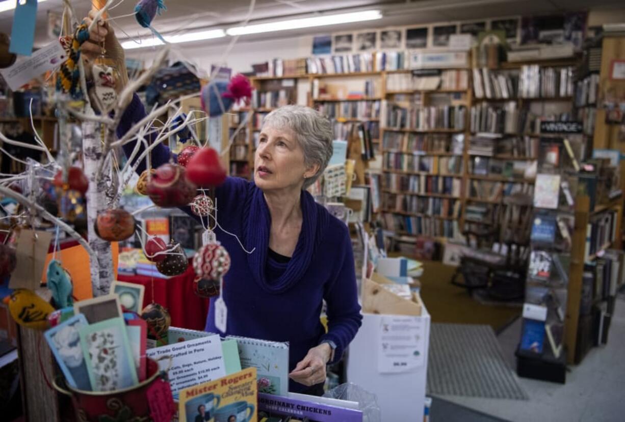 Vintage Books owner Becky Milner hangs ornaments in a holiday display at Vintage Books in Vancouver on Tuesday. Milner said the store will have a variety of activities to celebrate Small Business Saturday including author talks, kids crafts and giveaways.