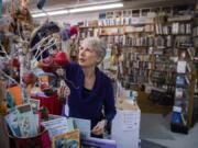 Vintage Books owner Becky Milner hangs ornaments in a holiday display at Vintage Books in Vancouver on Tuesday. Milner said the store will have a variety of activities to celebrate Small Business Saturday including author talks, kids crafts and giveaways.