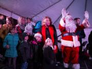 Mayor Anne McEnerny-Ogle, Santa and Princess Pearle (left, being held), 2, wave to a crowd of more than 5,000 people who came out to see the tree lighting Friday night in Esther Short Park. McEnerny-Ogle asked Pearle to help her officially light the tree this year.