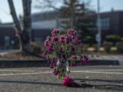 Flowers are seen Friday, Nov. 29, in the parking spot where two people were shot Nov. 26 in a domestic violence homicide and attempted homicide at Sarah J. Anderson Elementary School.