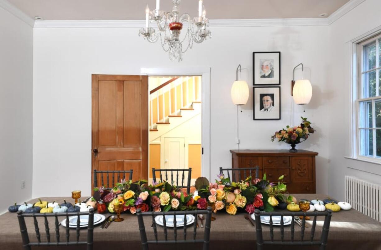 Flower designer Jo Oliver uses roses, seckle pears and thistle to showcase an unexpected autumn palette in her home in West River, Md. Over the chest, George Nelson&#039;s Cigar Sconces from Design Within Reach frame two illustrations by Washington artist Elizabeth Graeber.