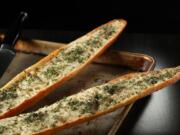 The warm garlic bread is finished with fresh herbs, like sage, thyme, chives and oregano.