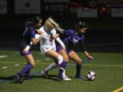 Columbia River's Yaneisy Rodriguez,right, fights for the ball against Ridgefield's Annika Farley, center, during the 2A district championship at Columbia River High School in Vancouver on Nov. 7, 2019. Ridgefield won 2-1.