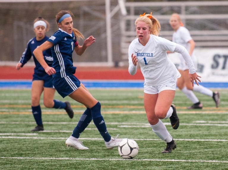 Ridgefield's Elizabeth Farley dribbles by Isabelle Moultray.