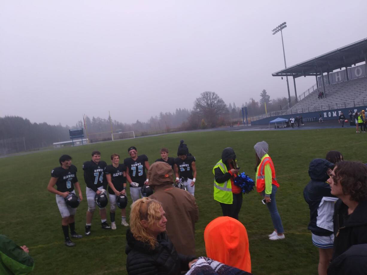 Hockinson players pose for pictures on the field after their 59-7 win over Centralia in a 2A district playoff on Saturday (Tim Martinez/The Columbian)