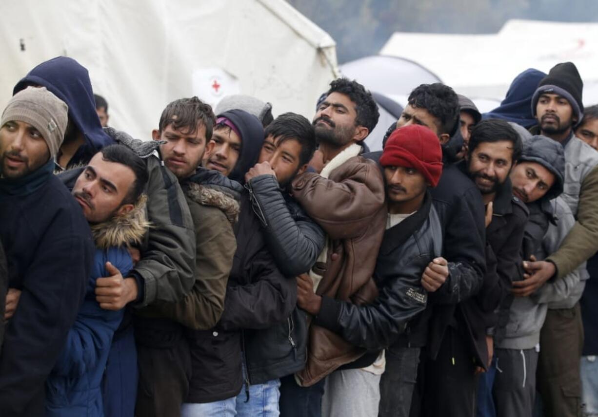 Migrants wait in line to receive supplies from the Red Cross at the Vucjak refugee camp outside Bihac, northwestern Bosnia, Thursday, Nov. 14, 2019. The European Union&#039;s top migration official is warning Bosnian authorities of a likely humanitarian crisis this winter due to appalling conditions in overcrowded migrant camps in the country.