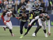 Seattle Seahawks quarterback Russell Wilson (3) scrambles away from Tampa Bay Buccaneers defensive end Jason Pierre-Paul (90) during overtime of an NFL football game, Sunday, Nov. 3, 2019, in Seattle.