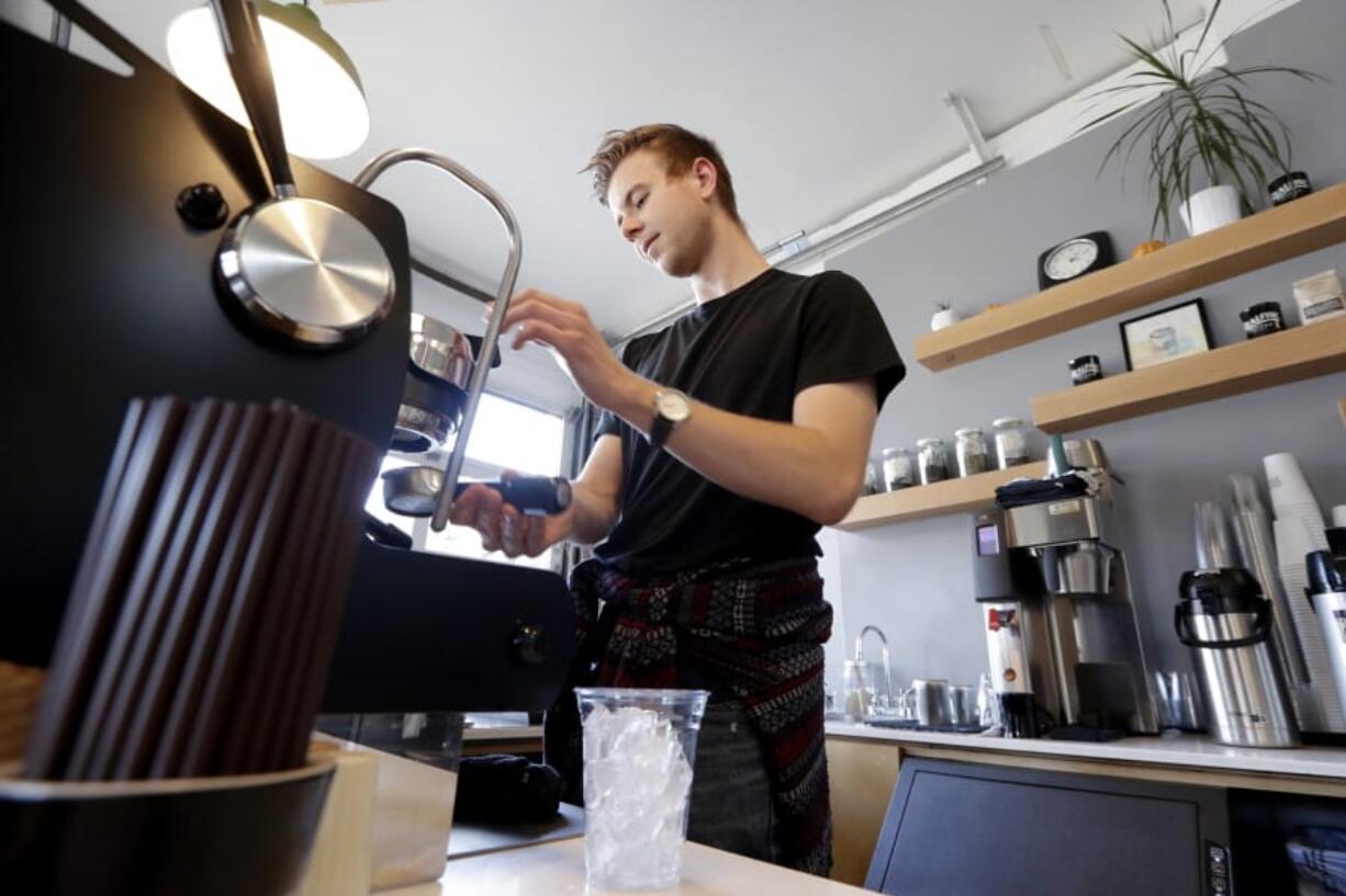 In this Monday, Nov. 4, 2019, photo, barista Porter Hahn makes an iced coffee drink for a customer in a coffee shop in Seattle. On Tuesday, Nov. 5, the Institute for Supply Management, a trade group of purchasing managers, issues its index of non-manufacturing activity for September.