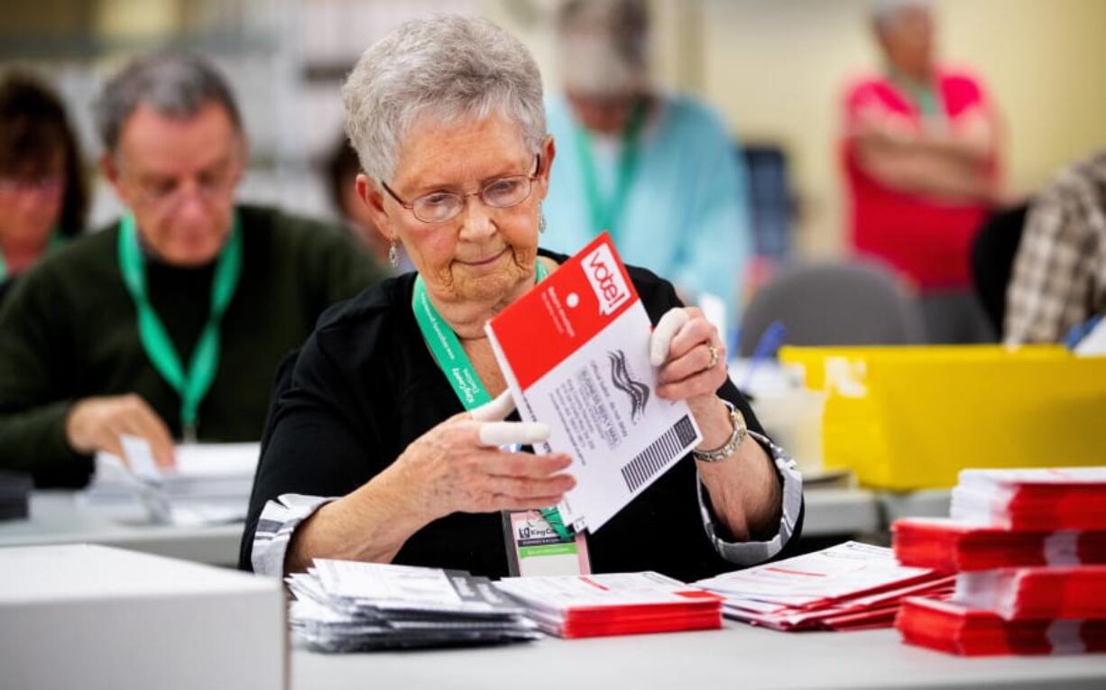 Election workers including Jan Reese open ballots at the King County Elections headquarters in Renton on Tuesday, Nov. 5, 2019.