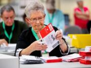 Election workers including Jan Reese open ballots at the King County Elections headquarters in Renton on Tuesday, Nov. 5, 2019.