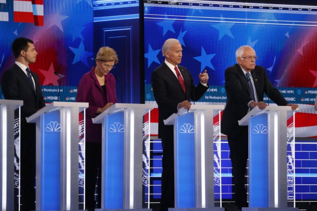 Democratic presidential candidate former Vice President Joe Biden, second from right, speaks as candidates Sen. Bernie Sanders, I-Vt.,, right, and South Bend, Ind., Mayor Pete Buttigieg, left, and Sen. Elizabeth Warren, D-Mass., second from left, watch during a Democratic presidential primary debate, Wednesday, Nov. 20, 2019, in Atlanta.