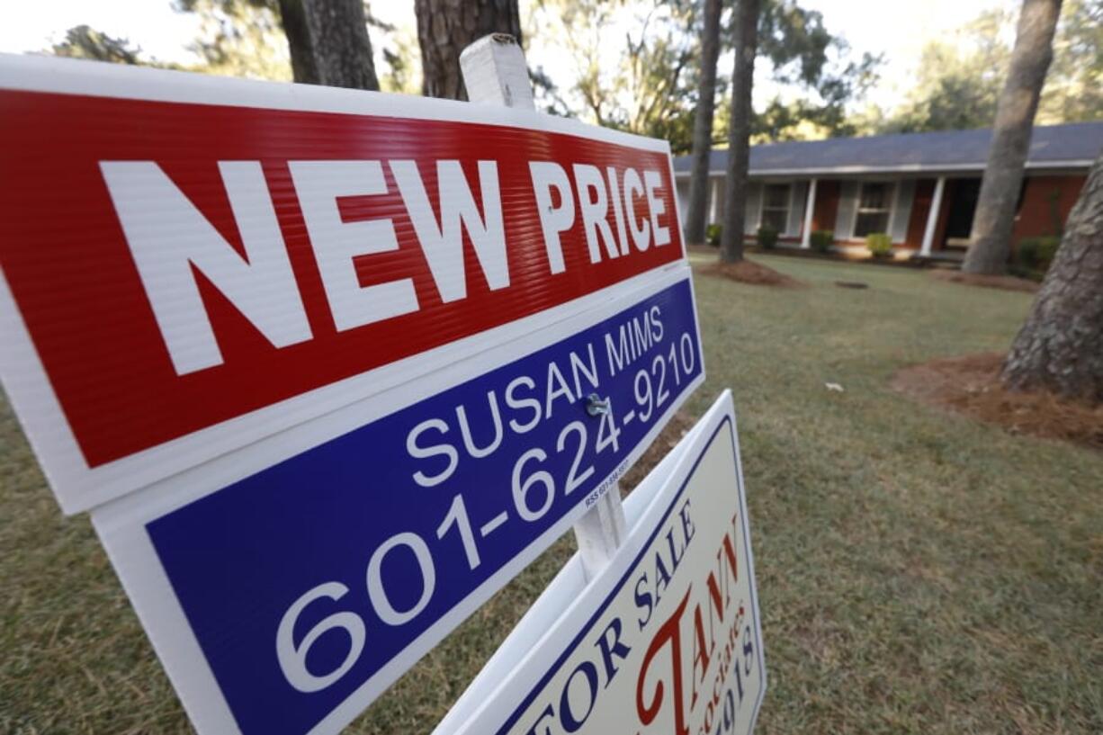 FILE - In this Sept. 25, 2019, file photo a sign indicating a new selling price for a house sits atop a realtor&#039;s sign in Jackson, Miss. On Tuesday, Nov. 26, the Standard &amp; Poor&#039;s/Case-Shiller 20-city home price index for September is released. (AP Photo/Rogelio V.