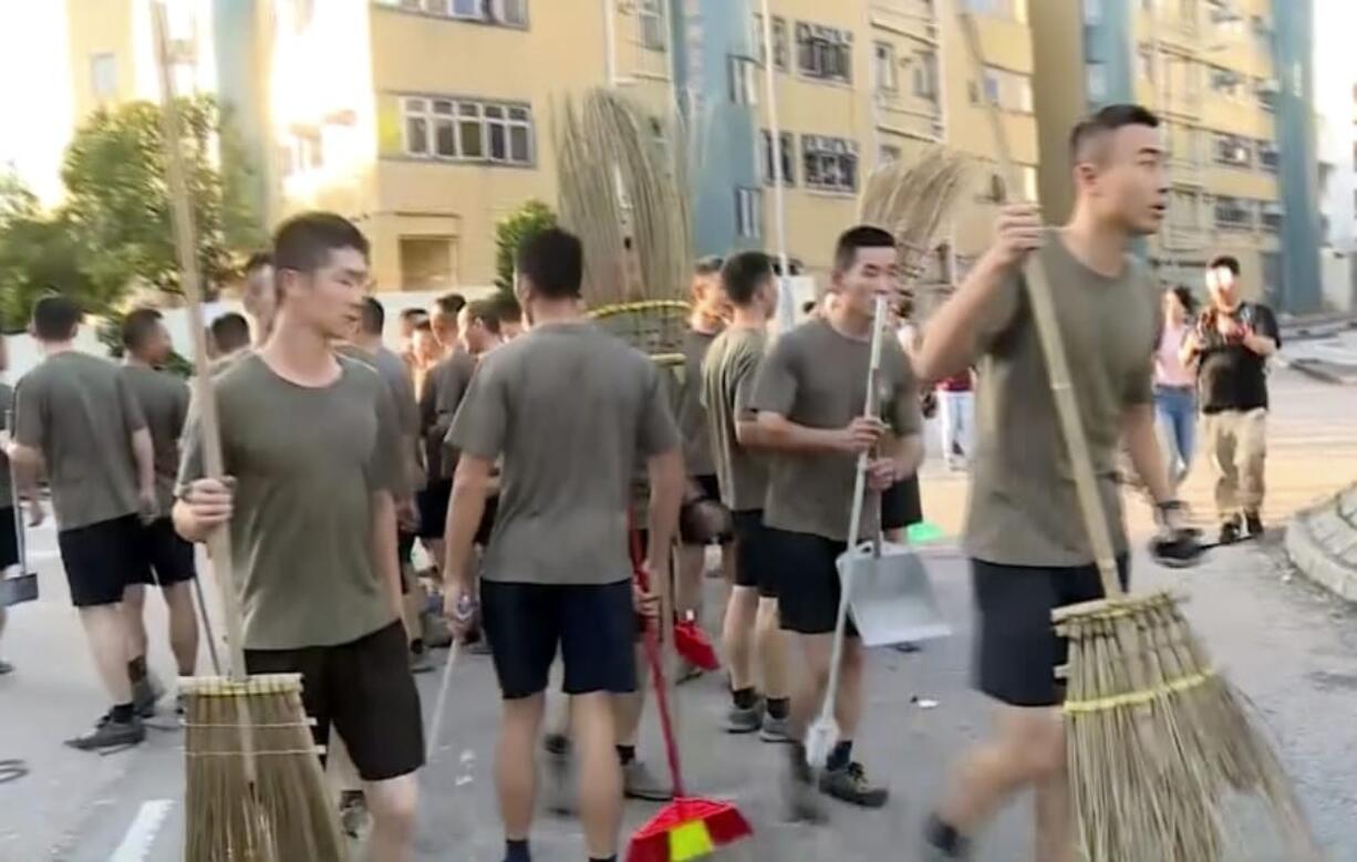 In this image made from video, People&#039;s Liberation Army soldiers, with brooms, arrive to clean up the protest area at Hong Kong Baptist University in Hong Kong, Saturday, Nov. 16, 2019. Troops from the Chinese army joined an effort to clean up debris outside the university, which was the site of clashes this week.