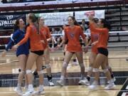 The Ridgefield volleyball team, including Emily Vossenkuhl (12) celebrate a point during a first-round victory over River Ridge at the 2A state tournament on Friday in Ellensburg.