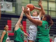 Union's Mason Oberg drives between a pair of Kentwood defenders in a girls basketball game at Union High School.