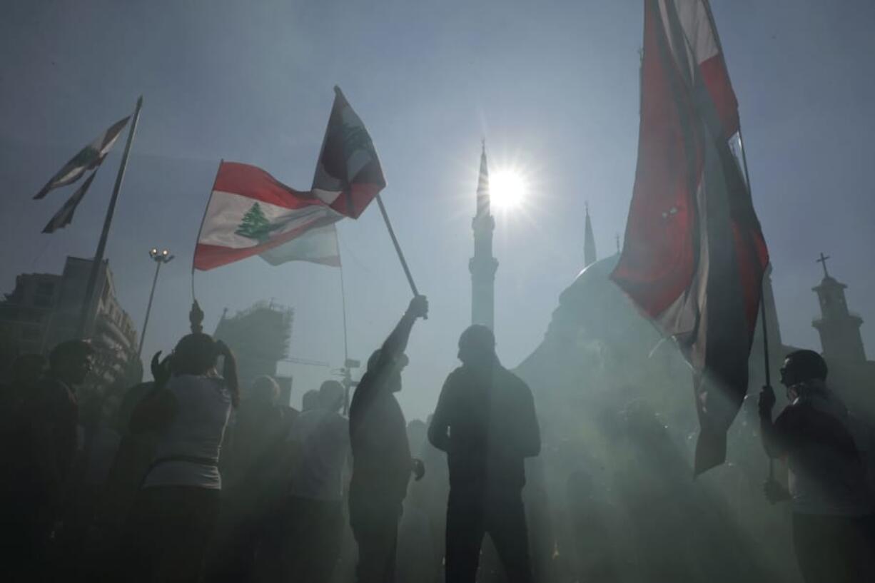 Anti-government protesters wave Lebanese national flags as gather during separate civil parade at the Martyr square, in downtown Beirut, Lebanon, Friday, Nov. 22, 2019. Protesters gathered for alternative independence celebrations, converging by early afternoon on Martyrs&#039; Square in central Beirut, which used to be the traditional location of the official parade. Protesters have occupied the area, closing it off to traffic since mid-October.