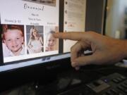 FILE - In this Tuesday, Nov. 5, 2019, file photo, Austin Cloes points to a photo of his relative Rhonita Miller and her family, who were killed in Mexico, on a computer screen, in Herriman, Utah. The recent slaying in Mexico of nine people who belonged to a Mormon offshoot community where some people practice polygamy shines a new spotlight on the ongoing struggle for the mainstream church to fight the association with plural marriage groups because of its past.