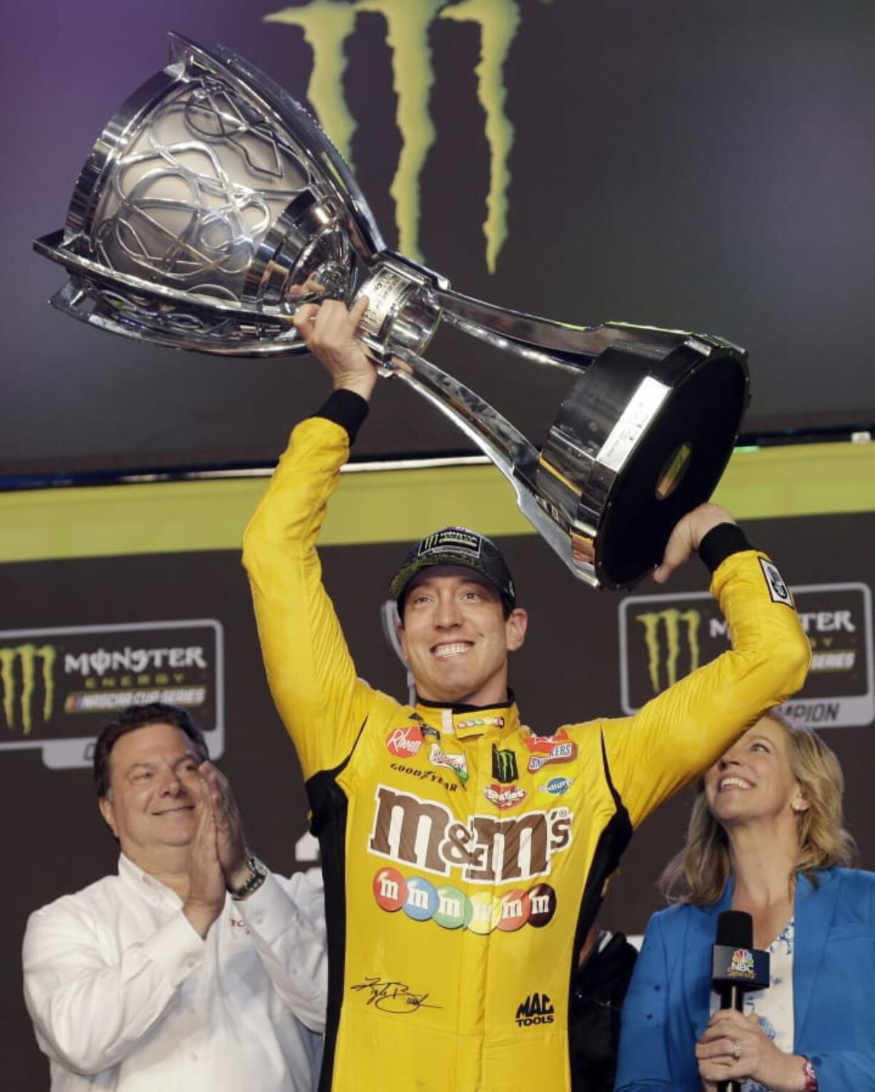 Kyle Busch holds up his trophy in Victory Lane after winning a NASCAR Cup Series auto racing season championship on Sunday, Nov. 17, 2019, at Homestead-Miami Speedway in Homestead, Fla.