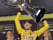 Kyle Busch holds up his trophy in Victory Lane after winning a NASCAR Cup Series auto racing season championship on Sunday, Nov. 17, 2019, at Homestead-Miami Speedway in Homestead, Fla.