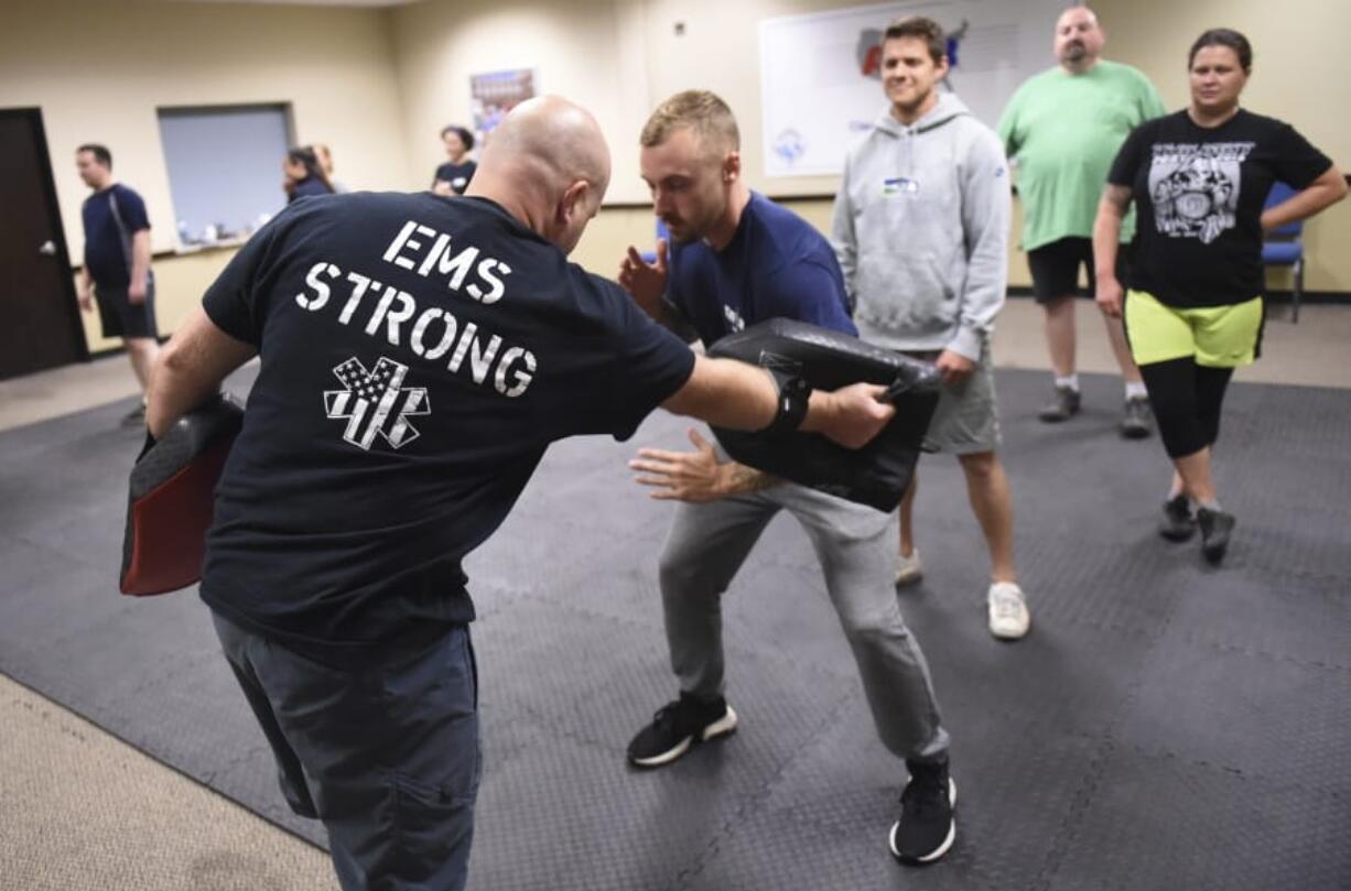 Ryan Russo, second from left, goes through a drill with instructor Sean Fuller, left, during a defensive tactic training class on Sept.