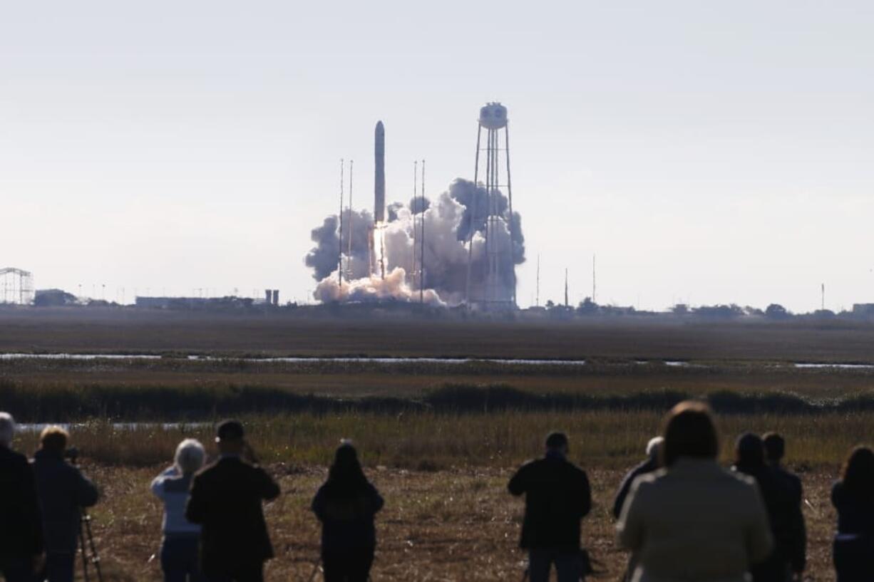 Spectators watch as Northrop Grumman&#039;s Antares rocket lifts off the launch pad at NASA Wallops Flight facility in Wallops Island, Va., Saturday, Nov. 2, 2019. The rocket is carrying a Cygnus spacecraft carrying supplies to the International Space Station.