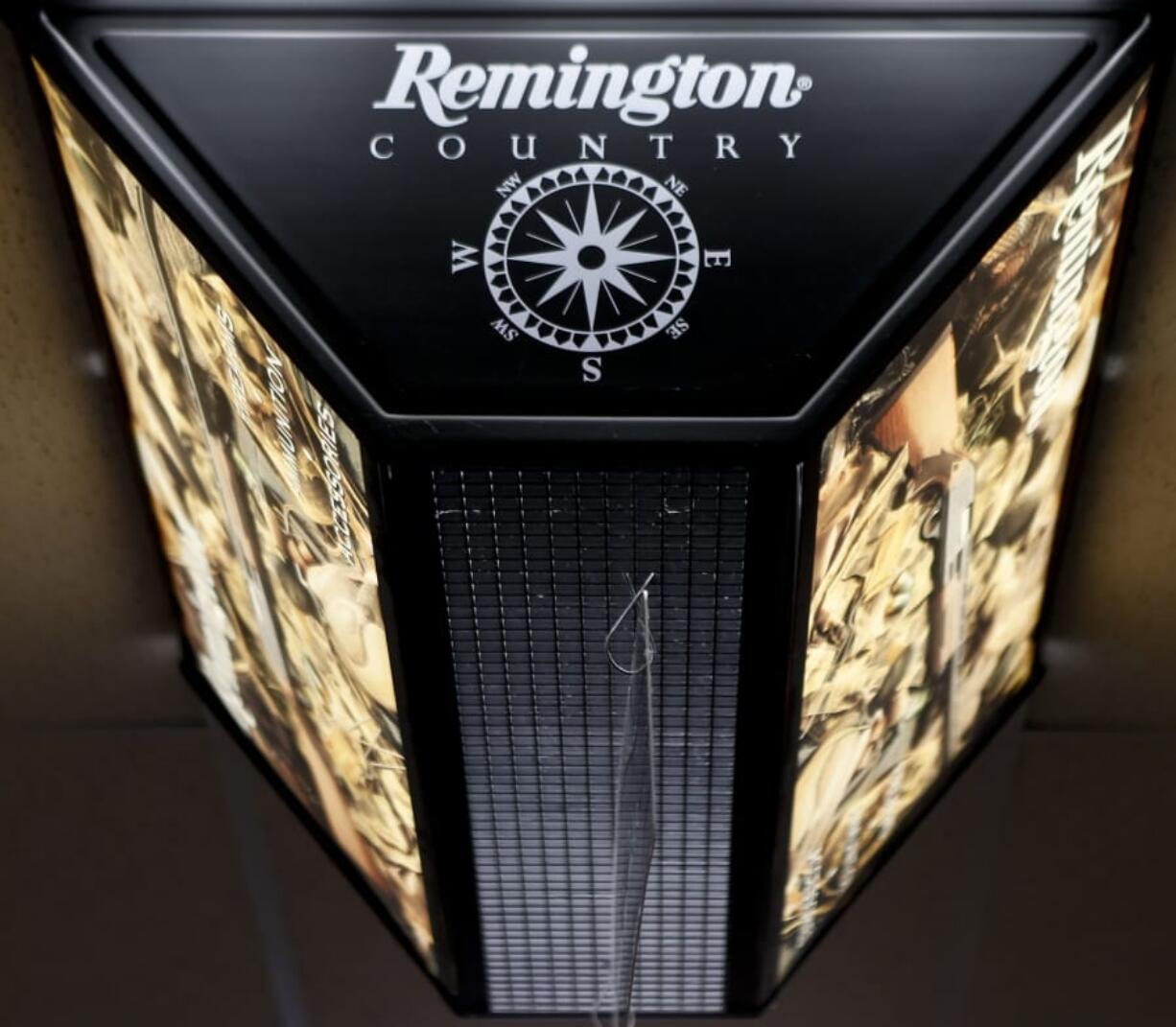 FILE - In this March 1, 2018 file photo, a light advertising Remington products hangs from the ceiling at Duke&#039;s Sport Shop in New Castle, Pa. For years, the gun industry has been immune from most lawsuits, but a recent ruling allowing families of victims in the Newton school shooting to challenge the way an AR-15 used by the shooter was marketed is upending that longstanding roadblock. The U.S.