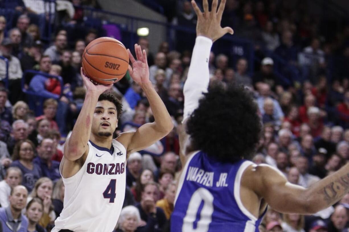 Gonzaga guard Ryan Woolridge (4) shoots over Texas-Arlington guard Brian Warren (0) during the second half of an NCAA college basketball game in Spokane, Wash., Tuesday, Nov. 19, 2019. Gonzaga won 72-66.