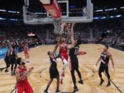 New Orleans Pelicans forward Brandon Ingram (14) goes to the basket between Portland Trail Blazers forward Skal Labissiere (17) and guard Kent Bazemore in the second half of an NBA basketball game in New Orleans, Tuesday, Nov. 19, 2019. The Pelicans won 115-104.