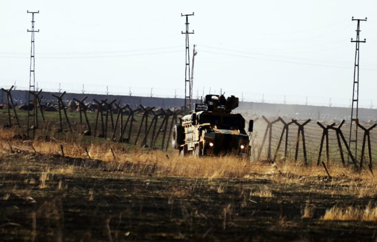 In this photo taken from the outskirts of the village of Alakamis, in Idil province, southeastern Turkey, a Turkish army vehicles is driven in Turkey after conducting a joint patrol with Russian forces in Syria, Friday, Nov. 8, 2019. The Britain-based Syrian Observatory for Human Rights says a protester has been killed when he was run over in the village of Sarmasakh, Syria near the border by a Turkish vehicle during a joint patrol with Russia.The man was among residents who pelted with shoes and stones Turkish and Russian troops who were conducting their third joint patrol in northeastern Syria, under a cease-fire deal brokered by Moscow that forced Kurdish fighters to withdraw from areas bordering Turkey.