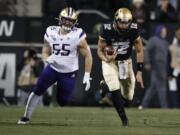 Colorado quarterback Steven Montez runs for a short gain as Washington linebacker Ryan Bowman pursues during the first half of an NCAA college football game Saturday, Nov. 23, 2019, in Boulder, Colo.