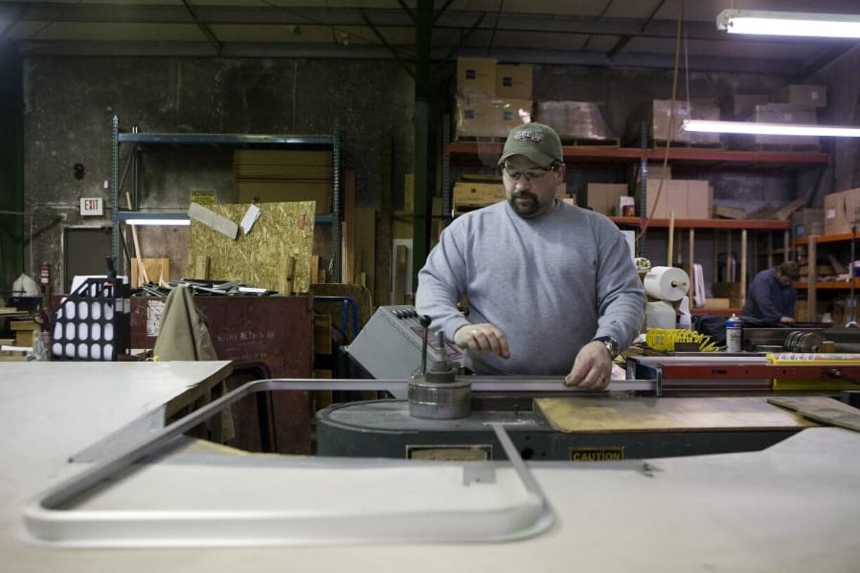 A worker at Peninsula Glass bends frames for fitting glass in 2009. Peninsula Glass specializes in custom-size tempered glass production.