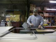 A worker at Peninsula Glass bends frames for fitting glass in 2009. Peninsula Glass specializes in custom-size tempered glass production.