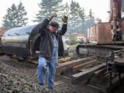 Matt Barton, vice president of the Chelatchie Prairie Railroad Association, signals that the engineer inching a locomotive along is running out of clear track. Behind Barton is the saddle-style water tank that was lifted off the group&#039;s 1929 steam engine during the federally mandated inspection.