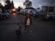 Lori Cuevas walks her dog up to the entrance of Sam&#039;s Good RV Park on Highway 99 in Hazel Dell on Nov. 25. She said she doesn&#039;t want to move from the park where she&#039;s lived for about 13 years.