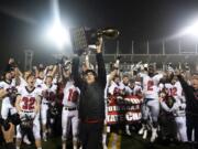 Camas head coach Jon Eagle hoists the trophy into the air after SaturdayÕs win in the Class 4A state championship game against Bothell at Mount Tahoma High School in Tacoma on Dec. 7, 2019.