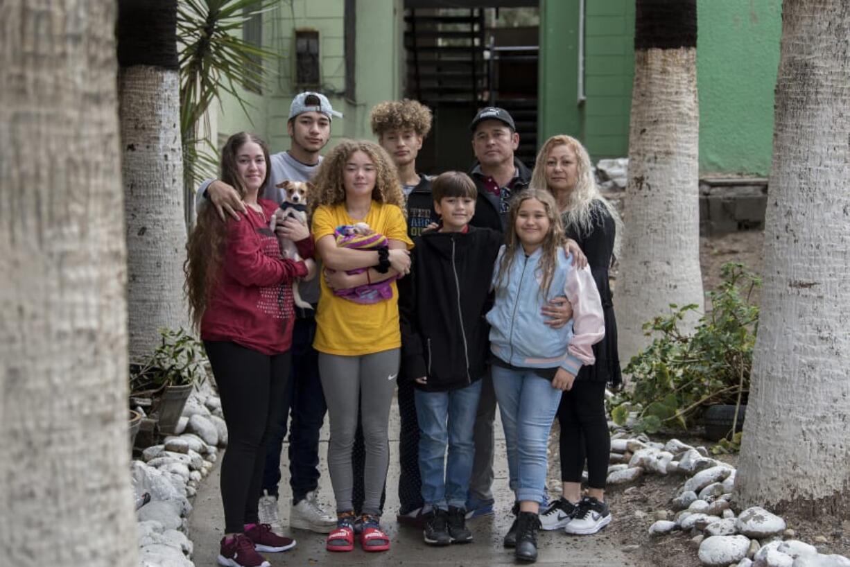 The Flores family pauses for a portrait outside Ramon&#039;s apartment complex in Tijuana, Mexico. Family members are, clockwise from left, Leslie, 23, Lennes, 18, Raymond, 15, Ramon, 46, Enedis, 54, Rayma, 10, Edward, 12, and Kennedy, 16.