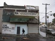 Ramon Flores walks from his car into the shop where he works as a carpenter Nov. 29 in Tijuana, Mexico.